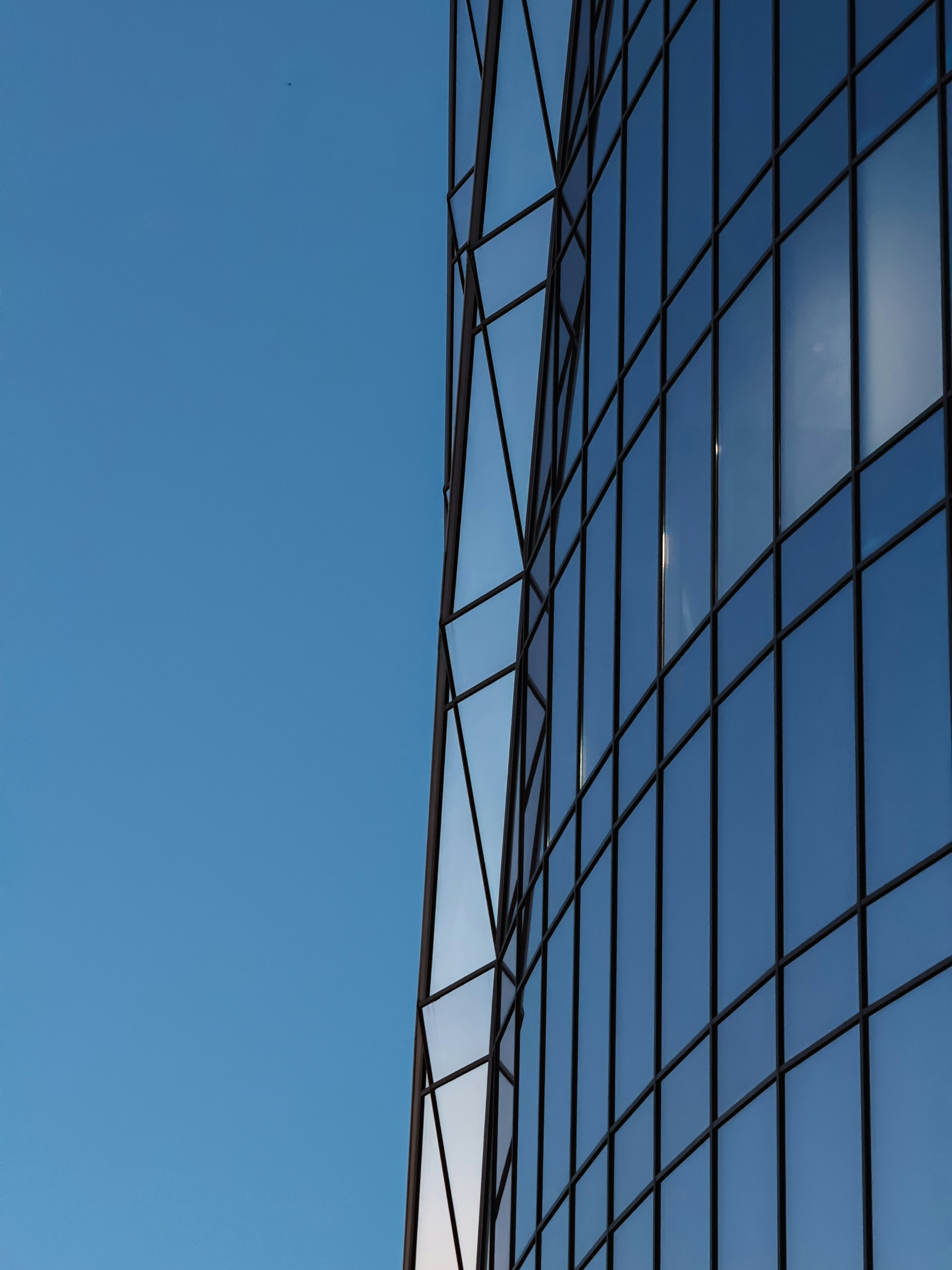 A plane flying in the air near a tall building
