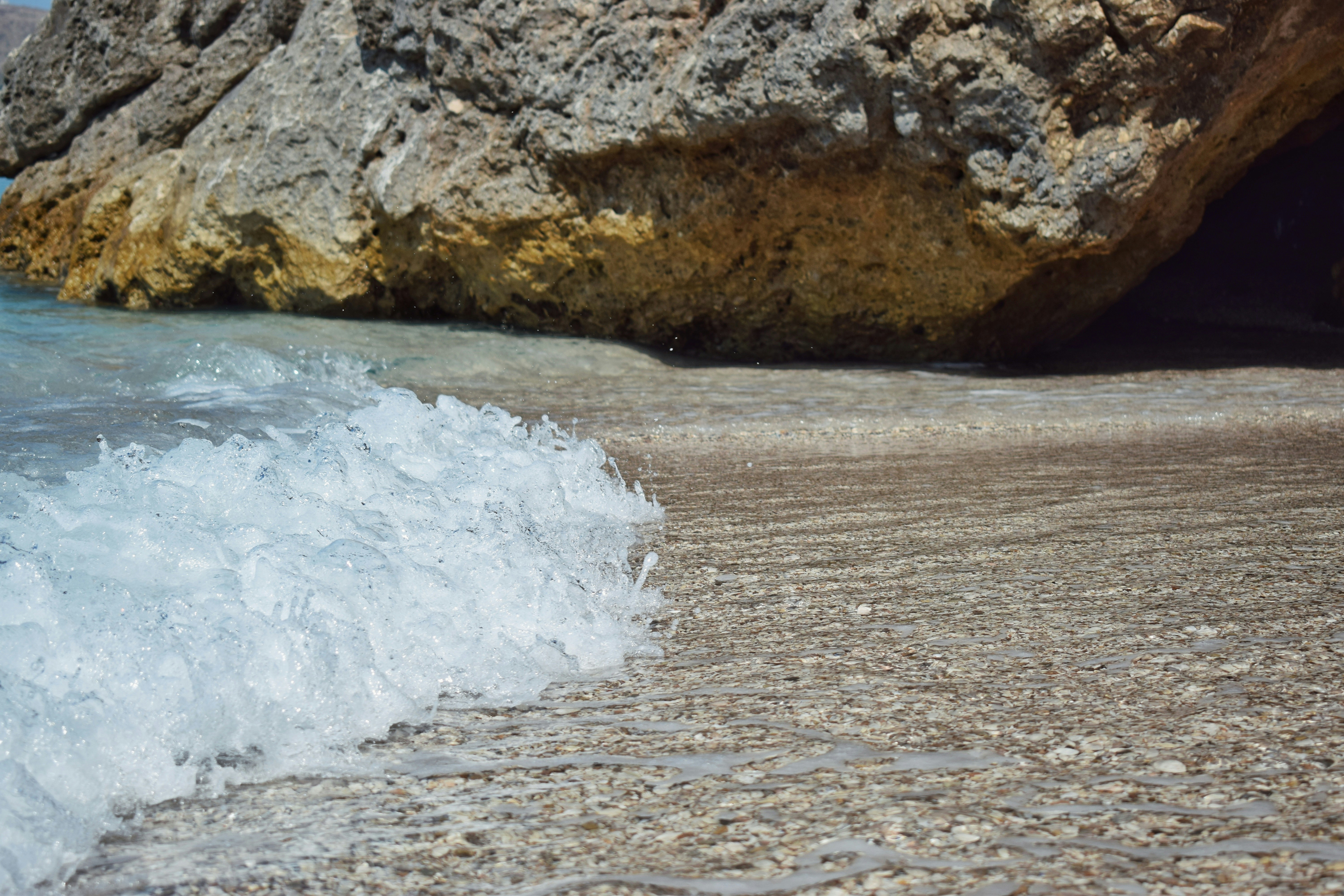 Ambiance estivale avec un rocher sur une plage de Qeparo face à la mer