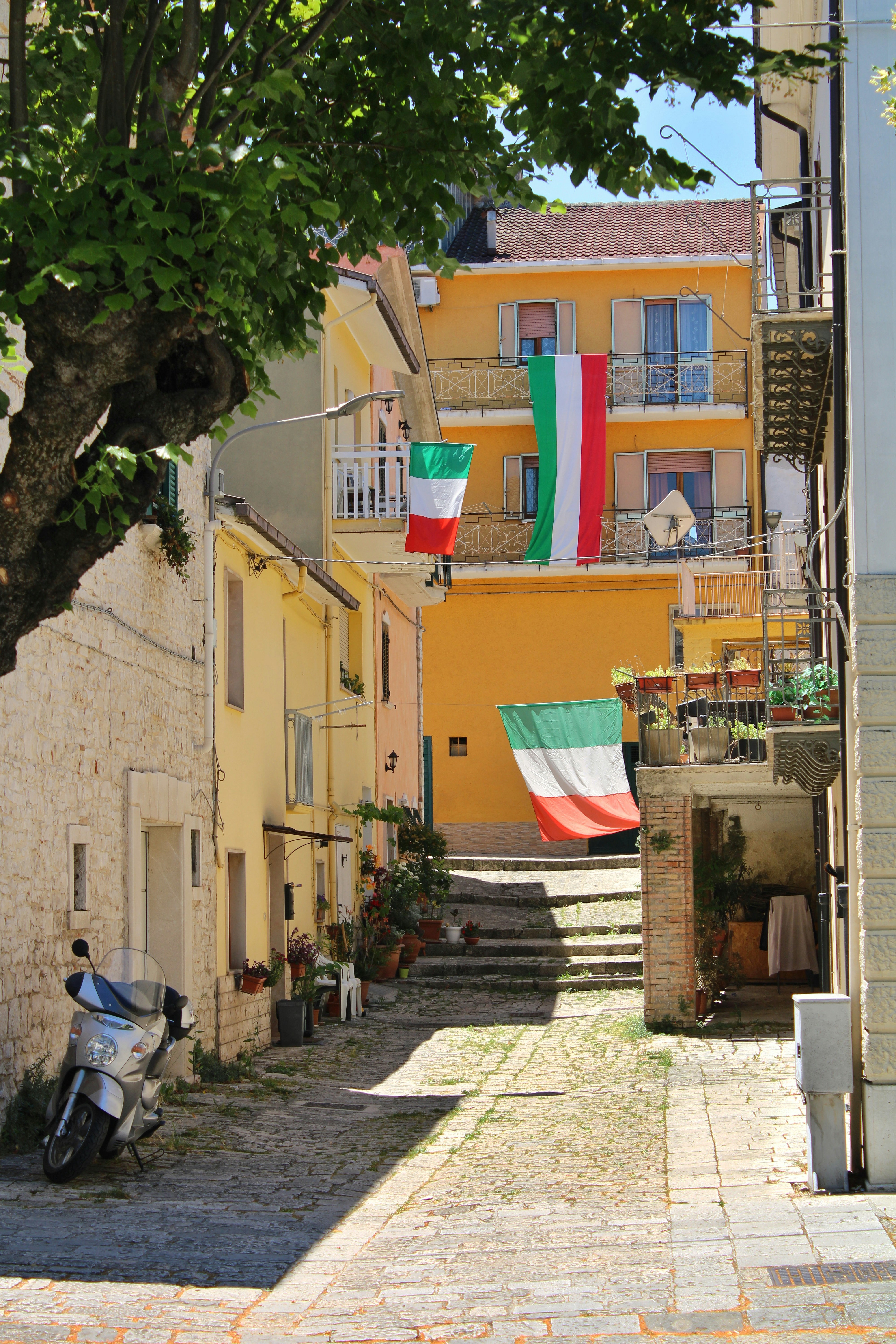 A narrow street with a motorcycle parked on the side of it