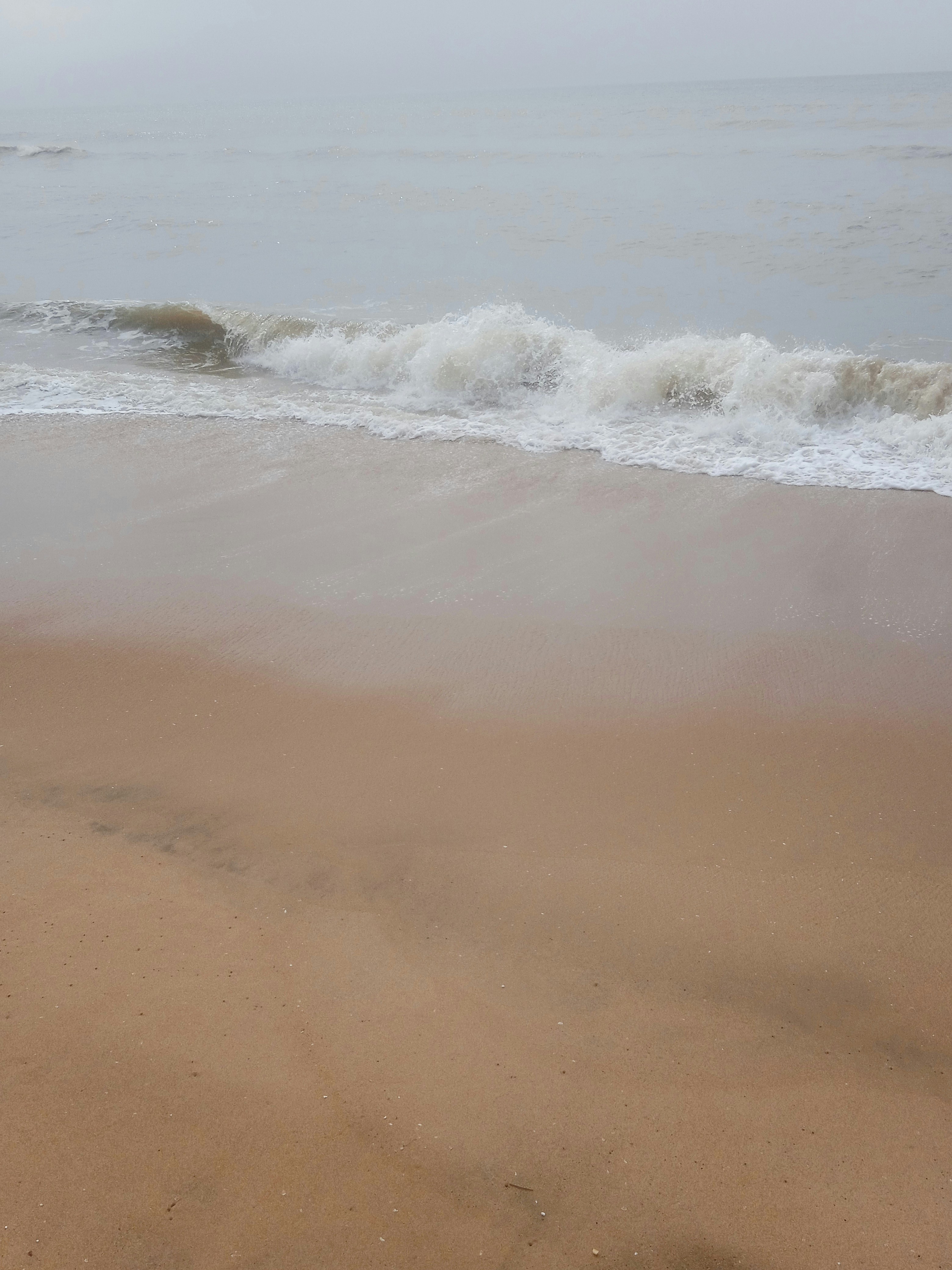 A sandy beach with waves coming in to shore photo – Free Beach Image on ...