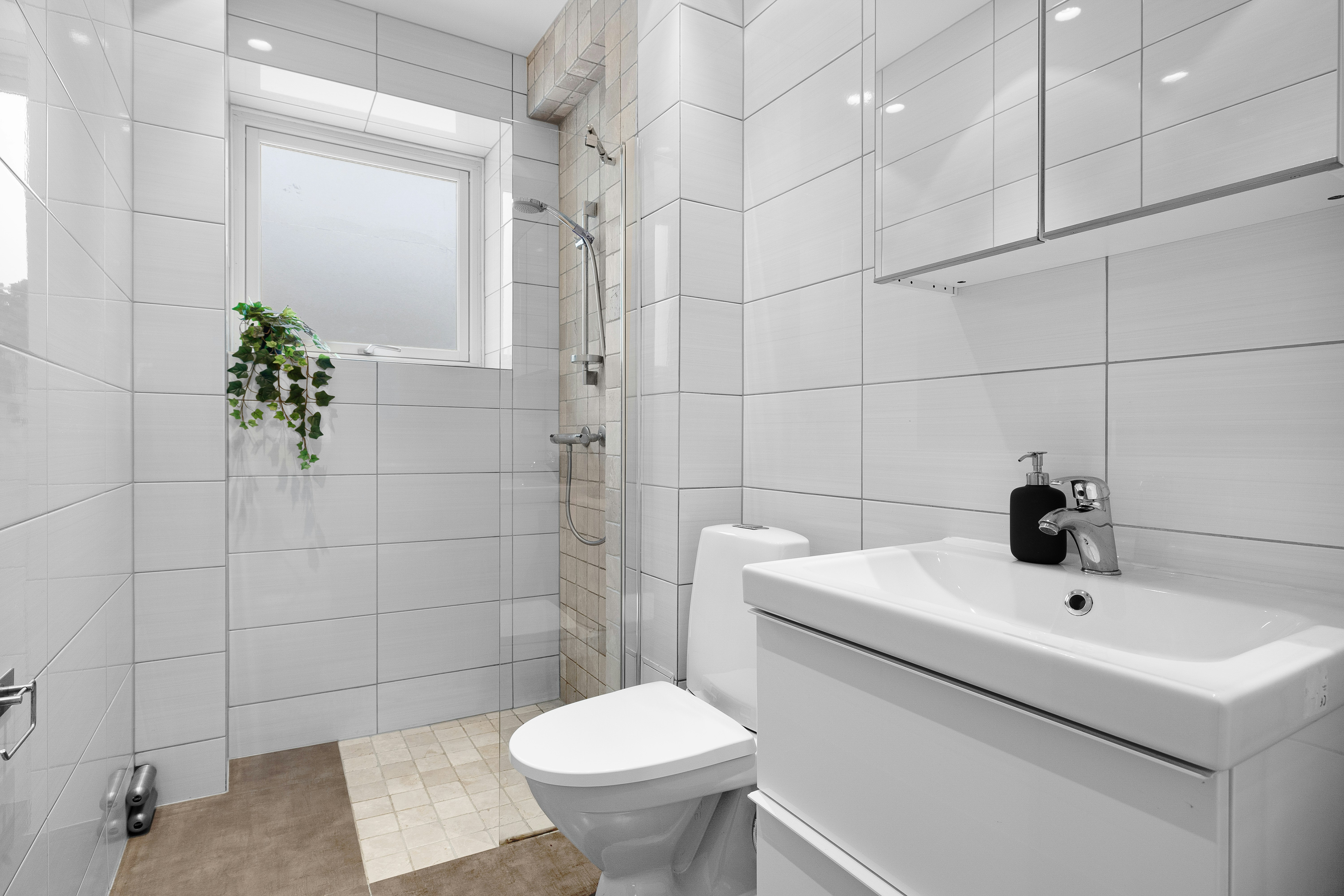 A bathroom with a toilet, sink, and mirror