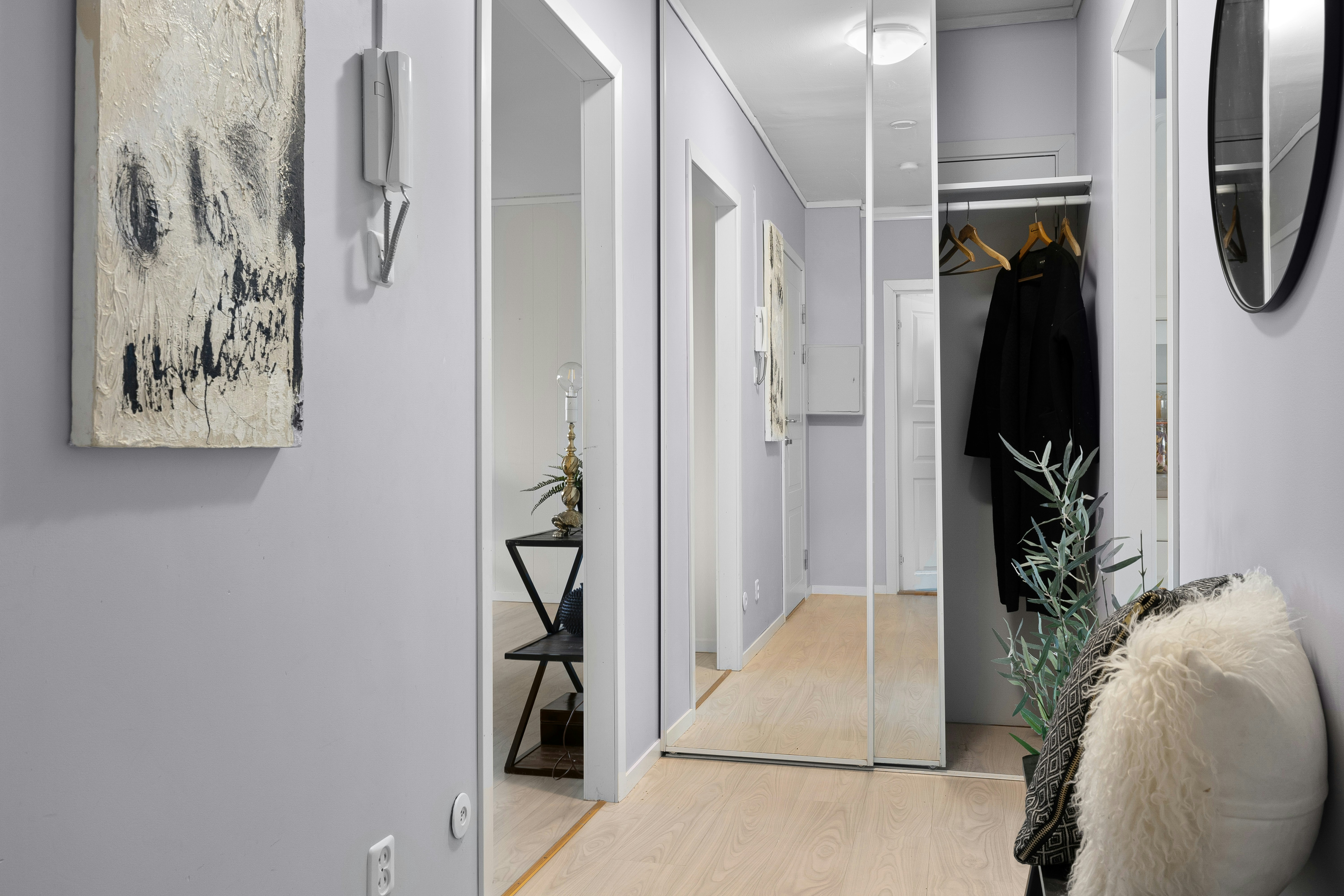 A hallway with a mirror and a coat rack