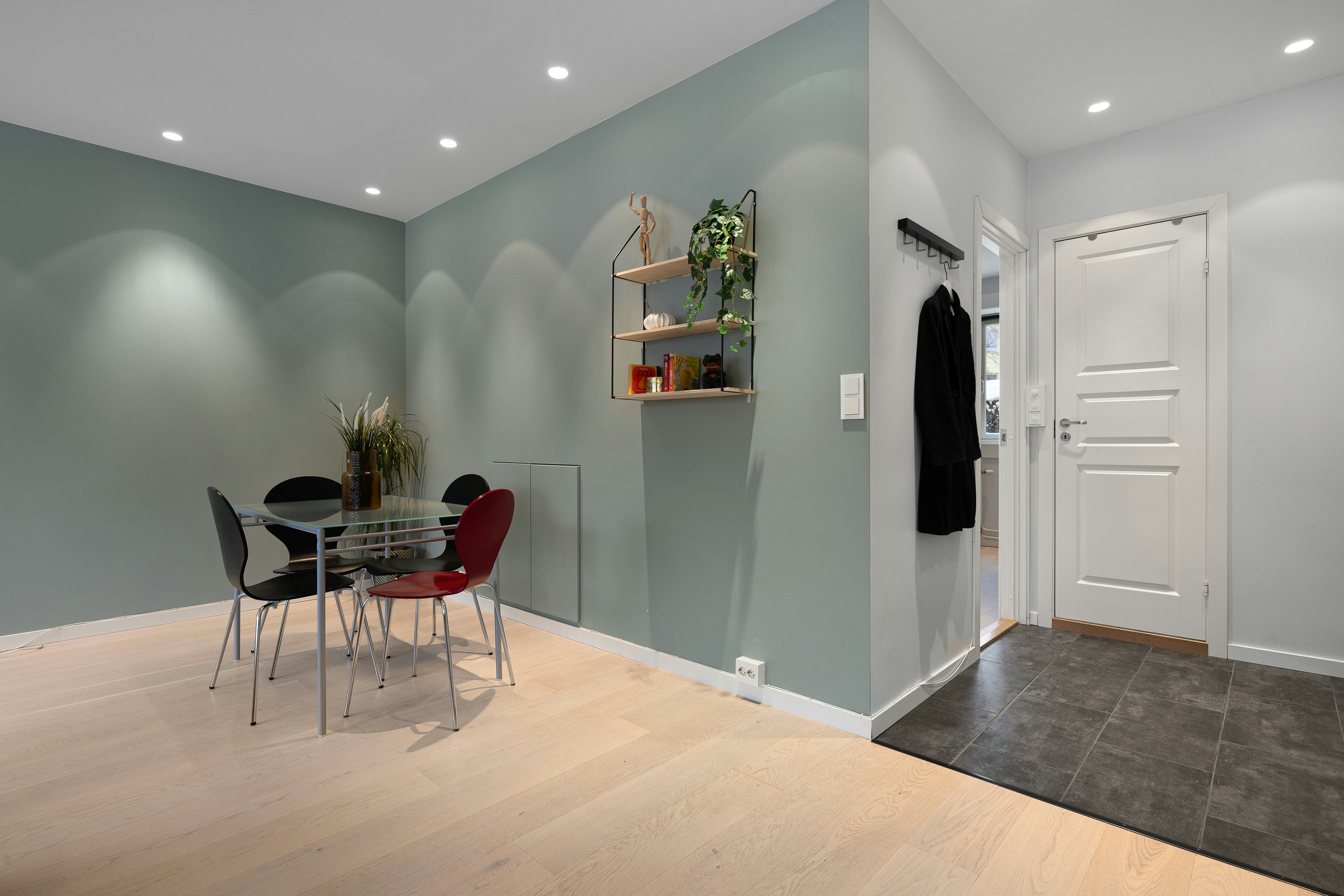 A room with a table, chairs, and a coat rack