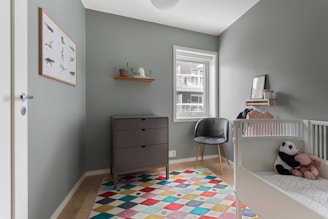 A baby's room with a crib and a teddy bear