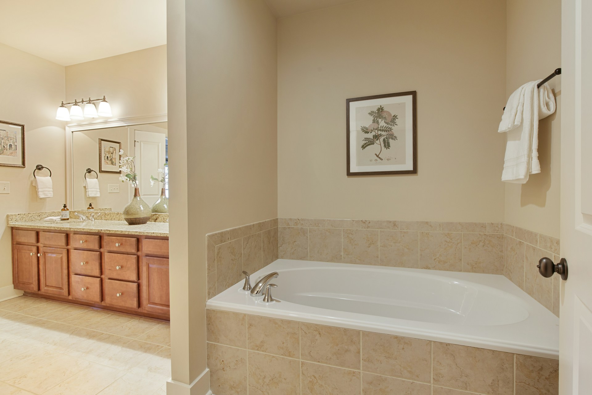 A bathroom with a tub, sink, and mirror