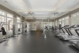 A gym filled with lots of machines and windows