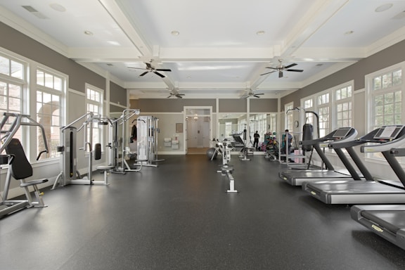 A gym filled with lots of machines and windows