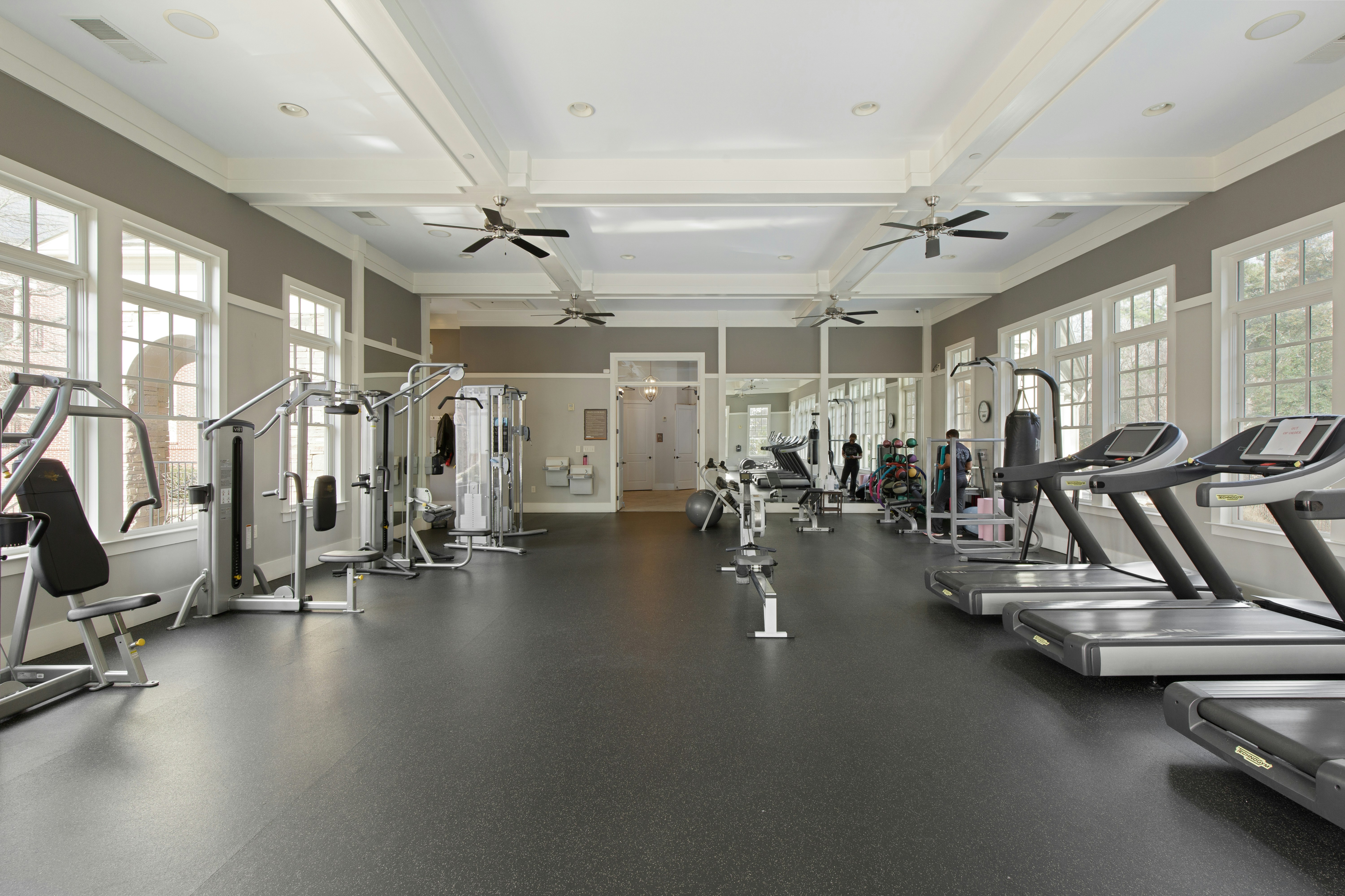 A gym filled with lots of machines and windows