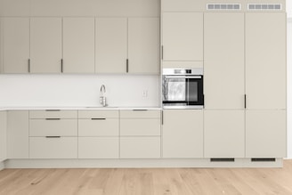 A kitchen with a stove, sink, and cabinets