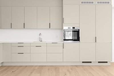 A kitchen with a stove, sink, and cabinets