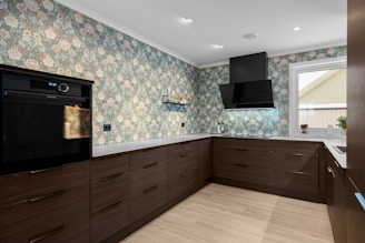 A kitchen with a stove, oven, cabinets and a window