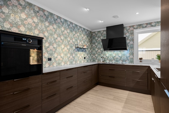 A kitchen with a stove, oven, cabinets and a window