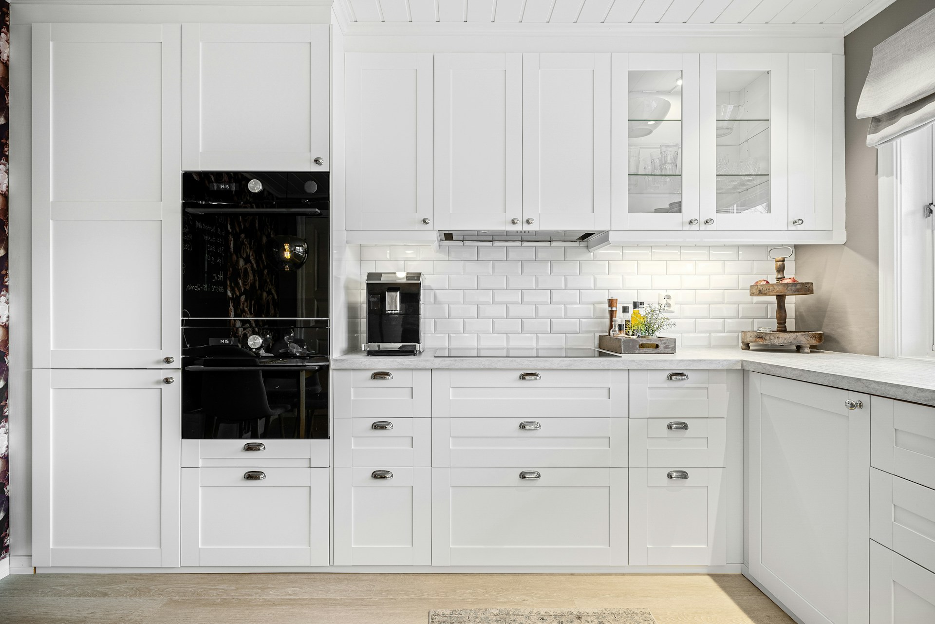 A kitchen with white cabinets and a black oven