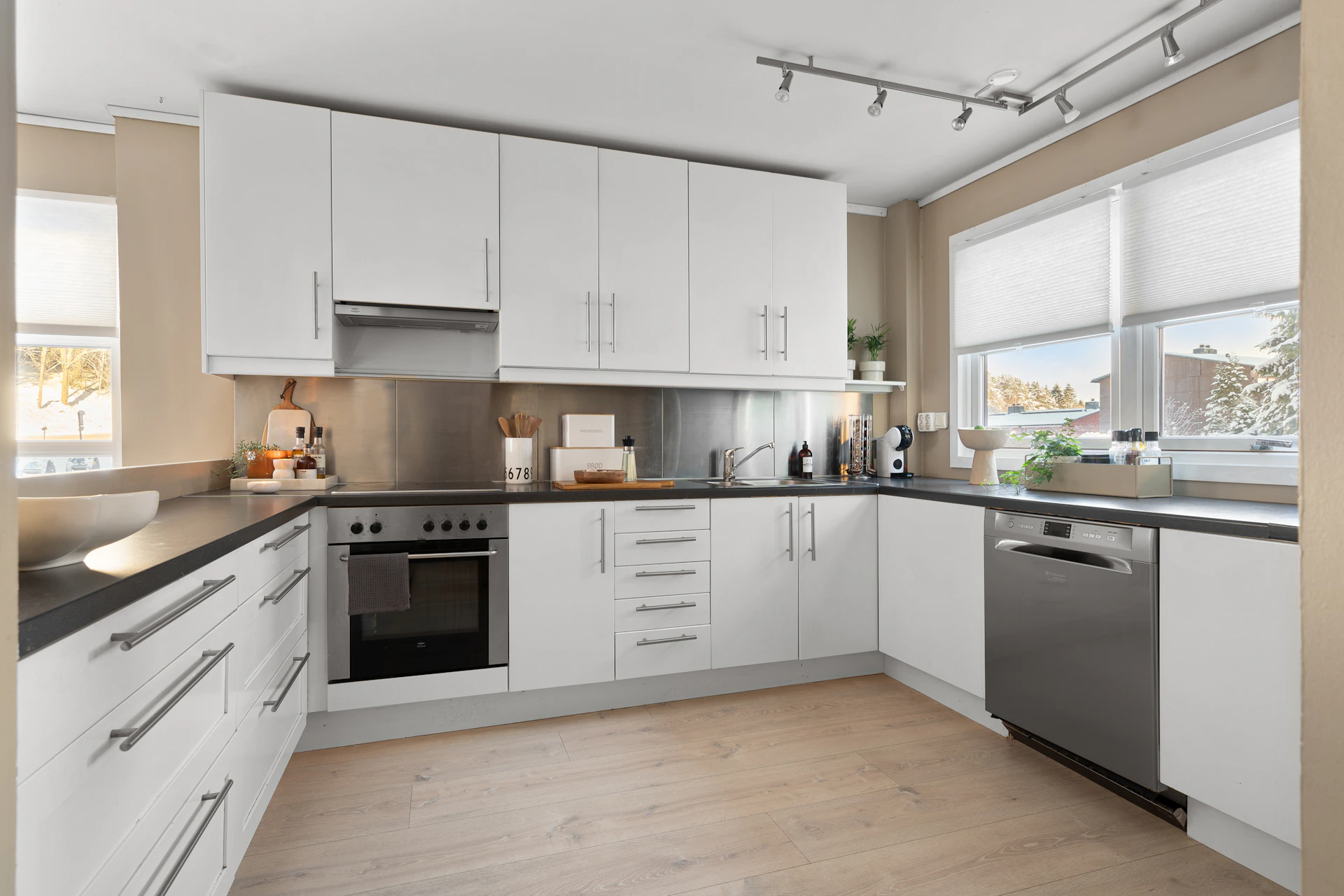 A kitchen with white cabinets and black counter tops