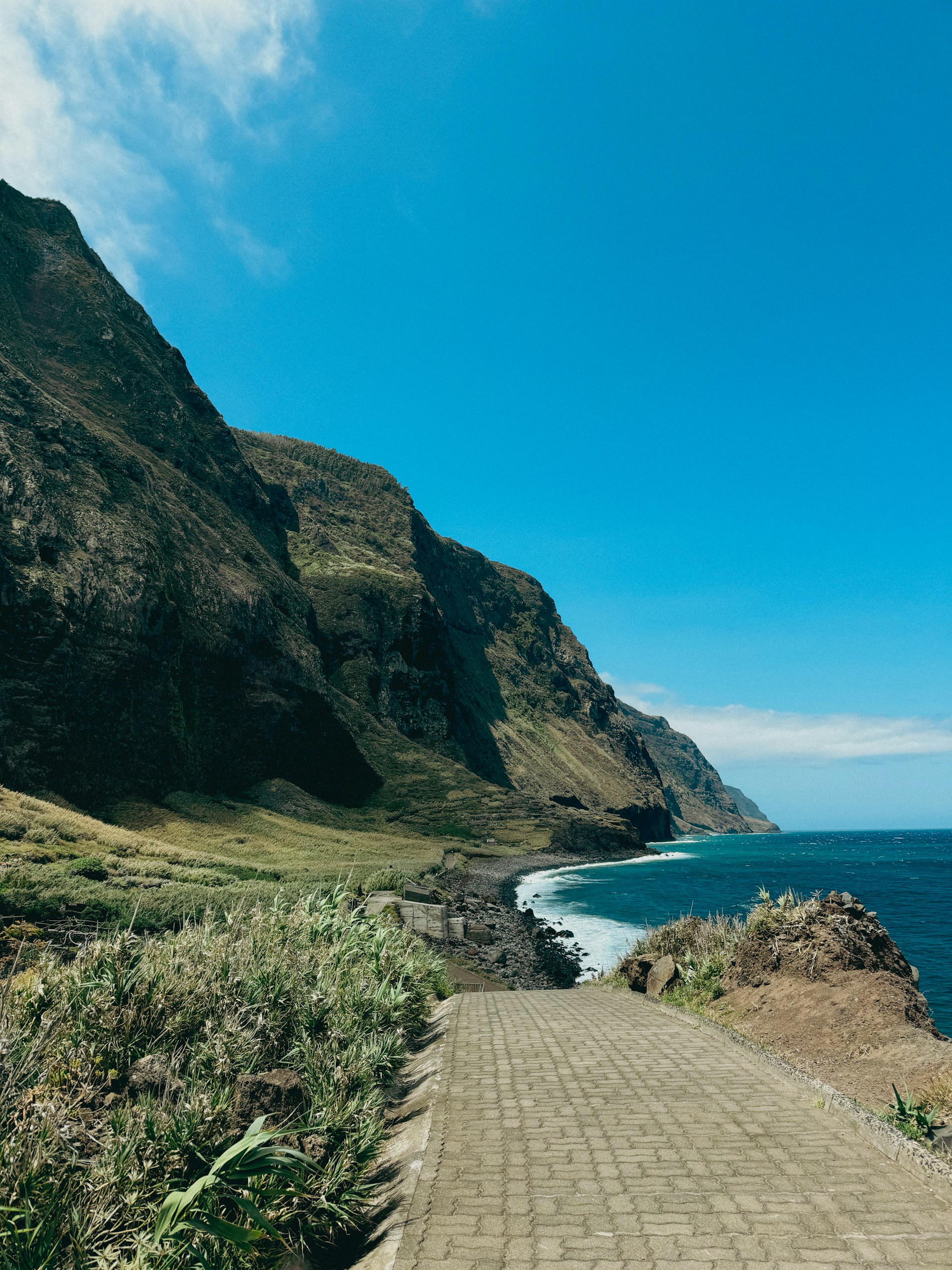 A brick path leading to the ocean on a sunny day