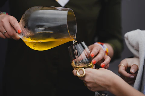 A woman pouring a glass of wine into another woman's hand