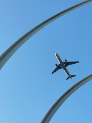 An airplane is flying through the blue sky