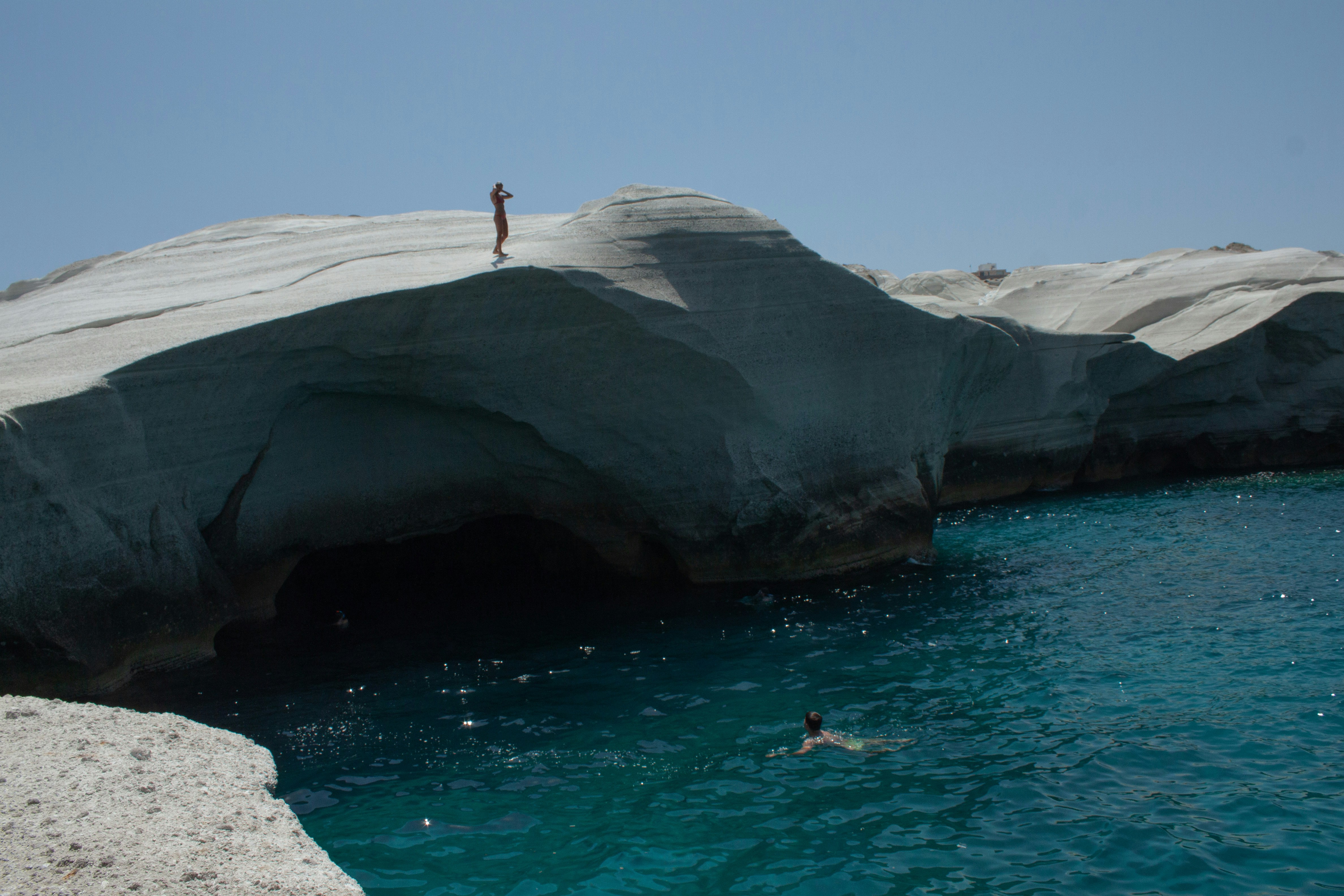 A person standing on a rock in the water