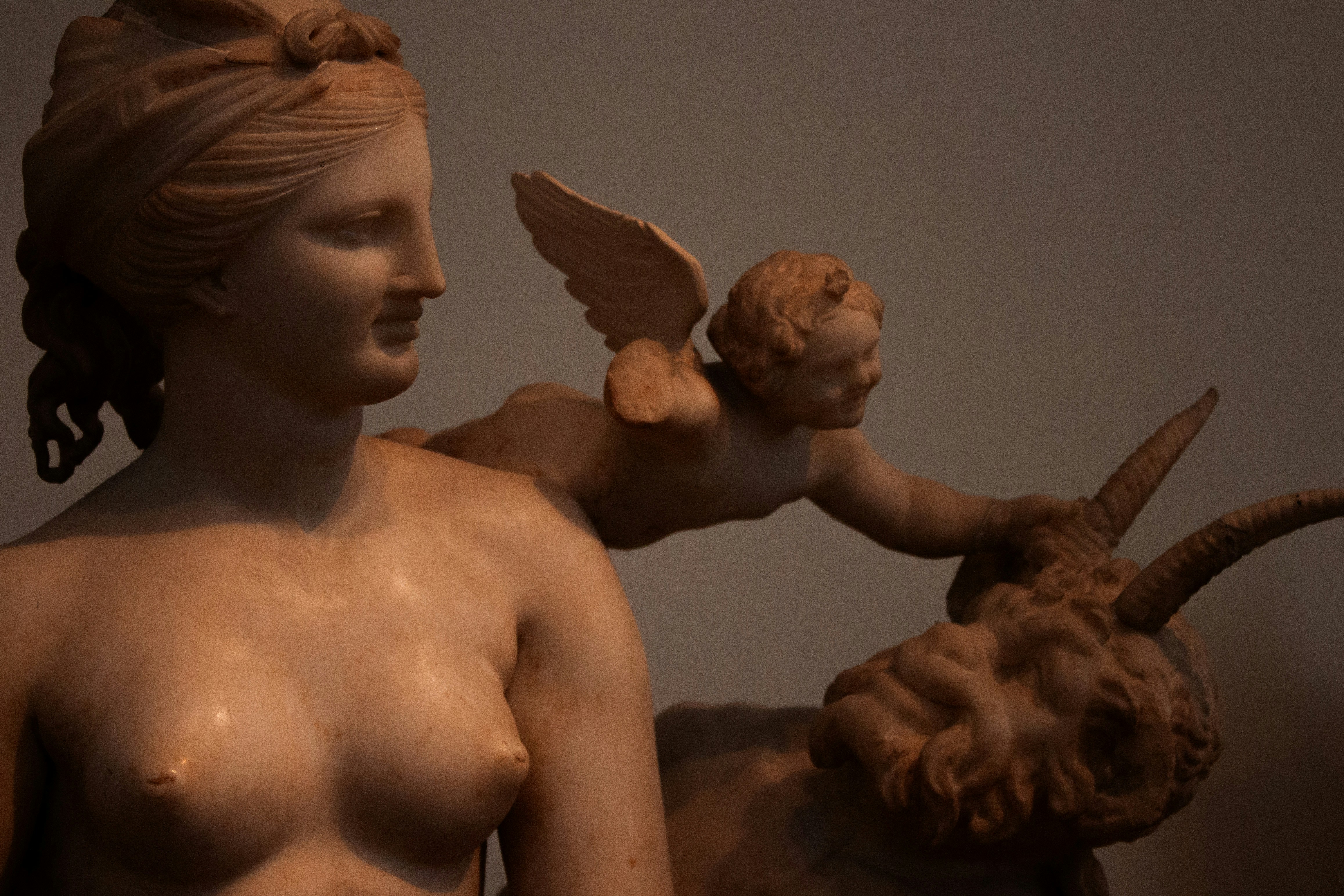 A statue of a woman holding a baby goat