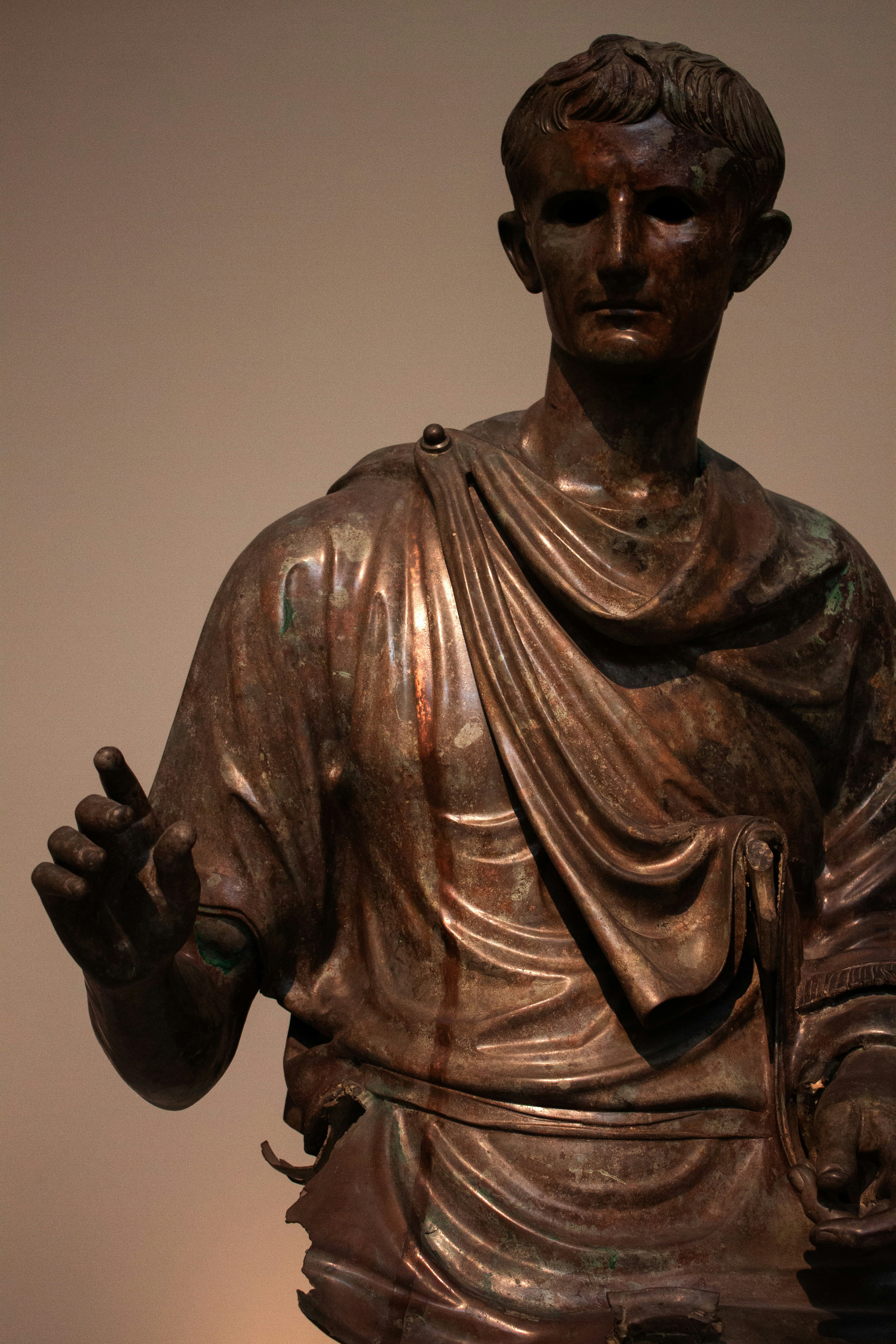 A bronze statue of a man holding his hands up