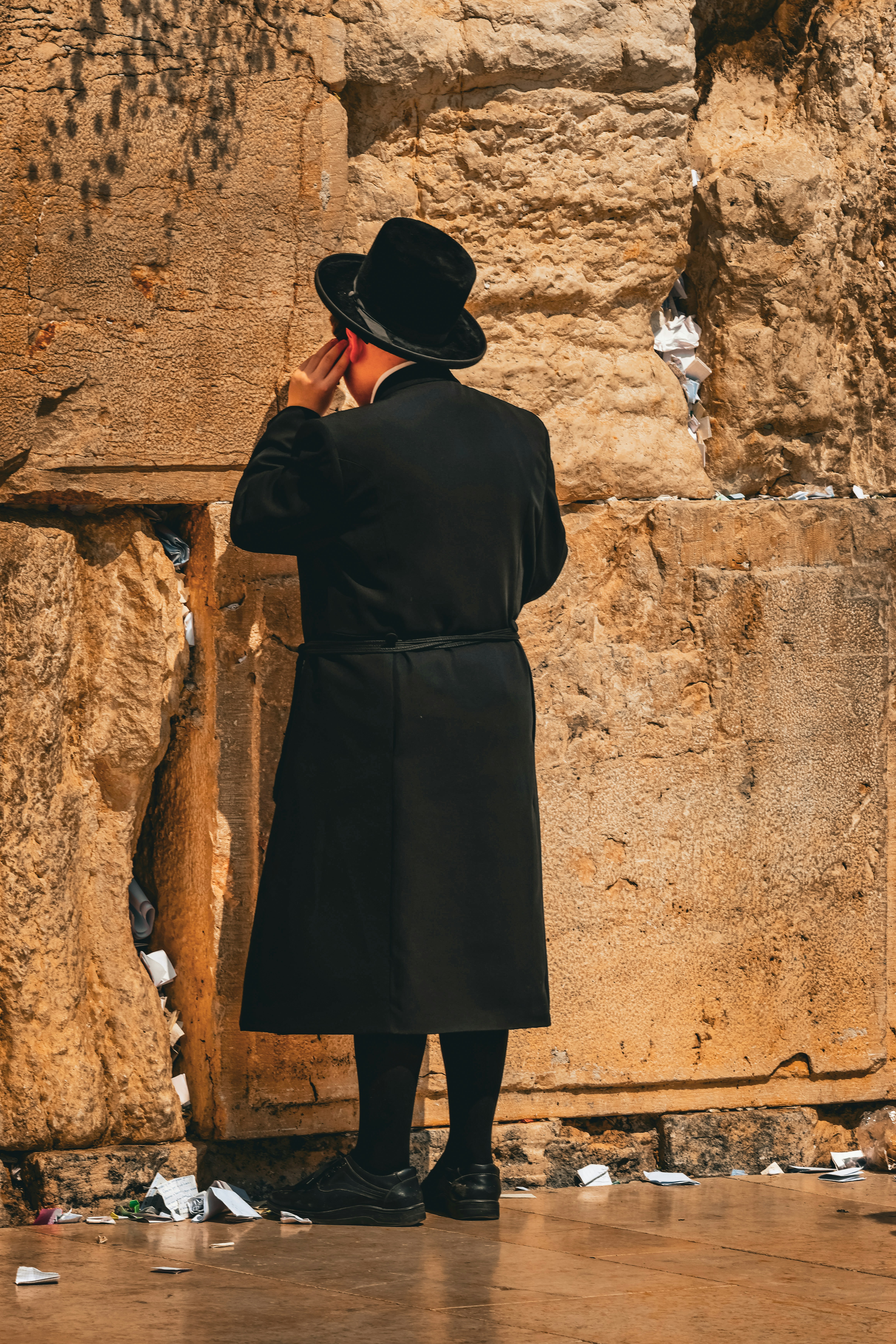 A man standing in front of a stone wall photo – Free Woman Image on ...