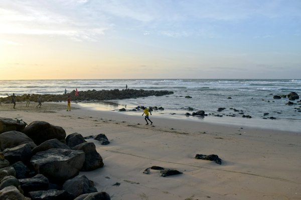 A person walking on a beach next to the ocean — Dakar, Senegal