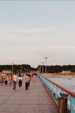 A group of people walking across a bridge