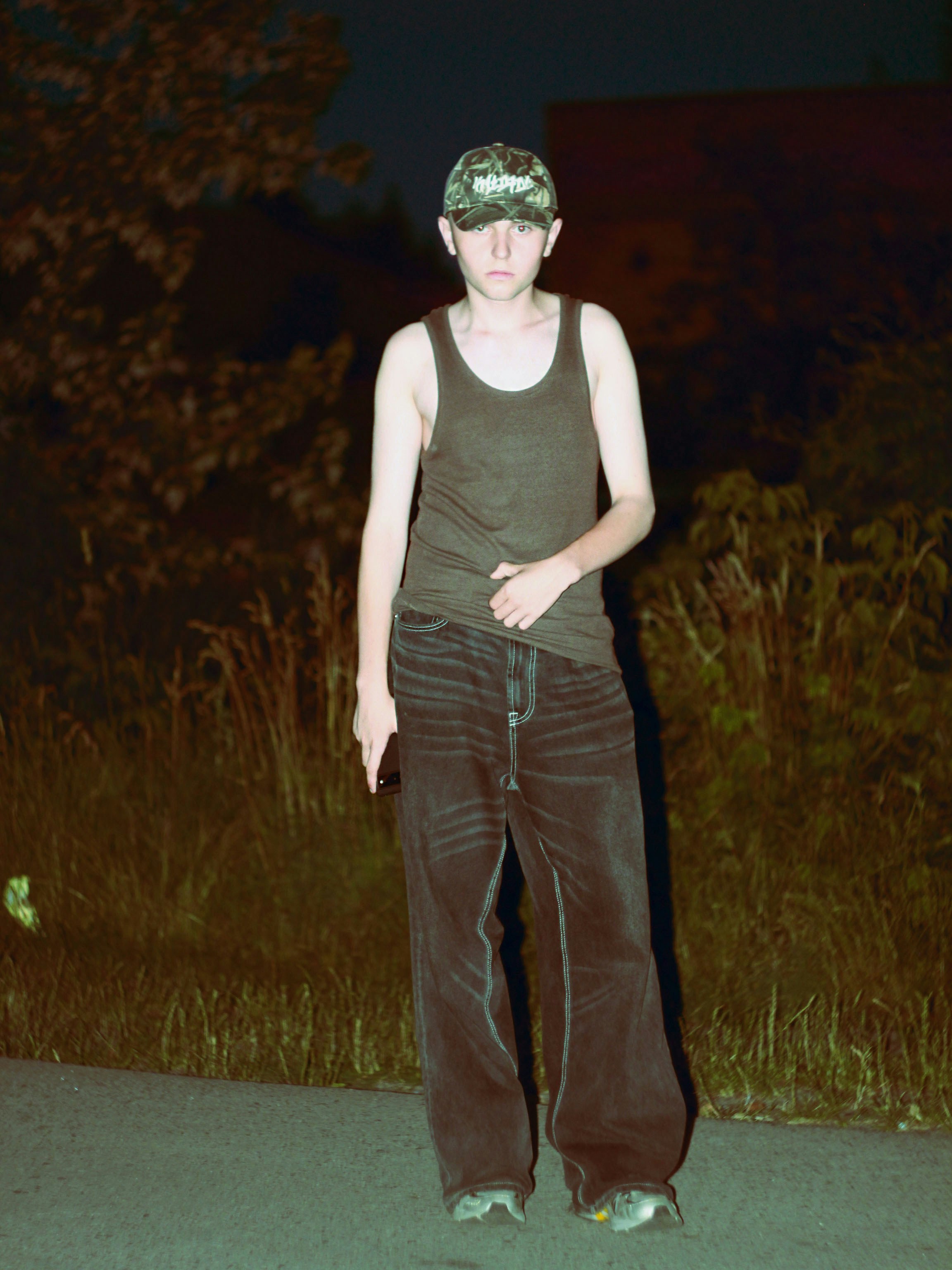 A young man standing in the middle of a road