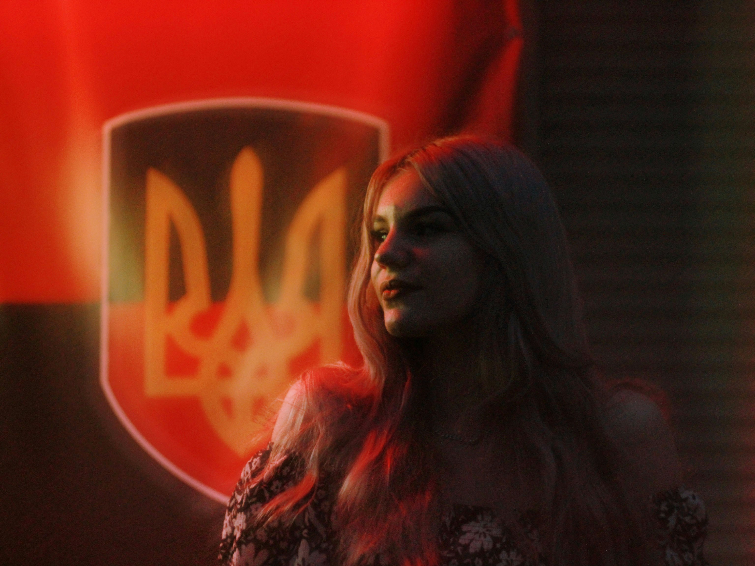 A woman standing in front of a red sign