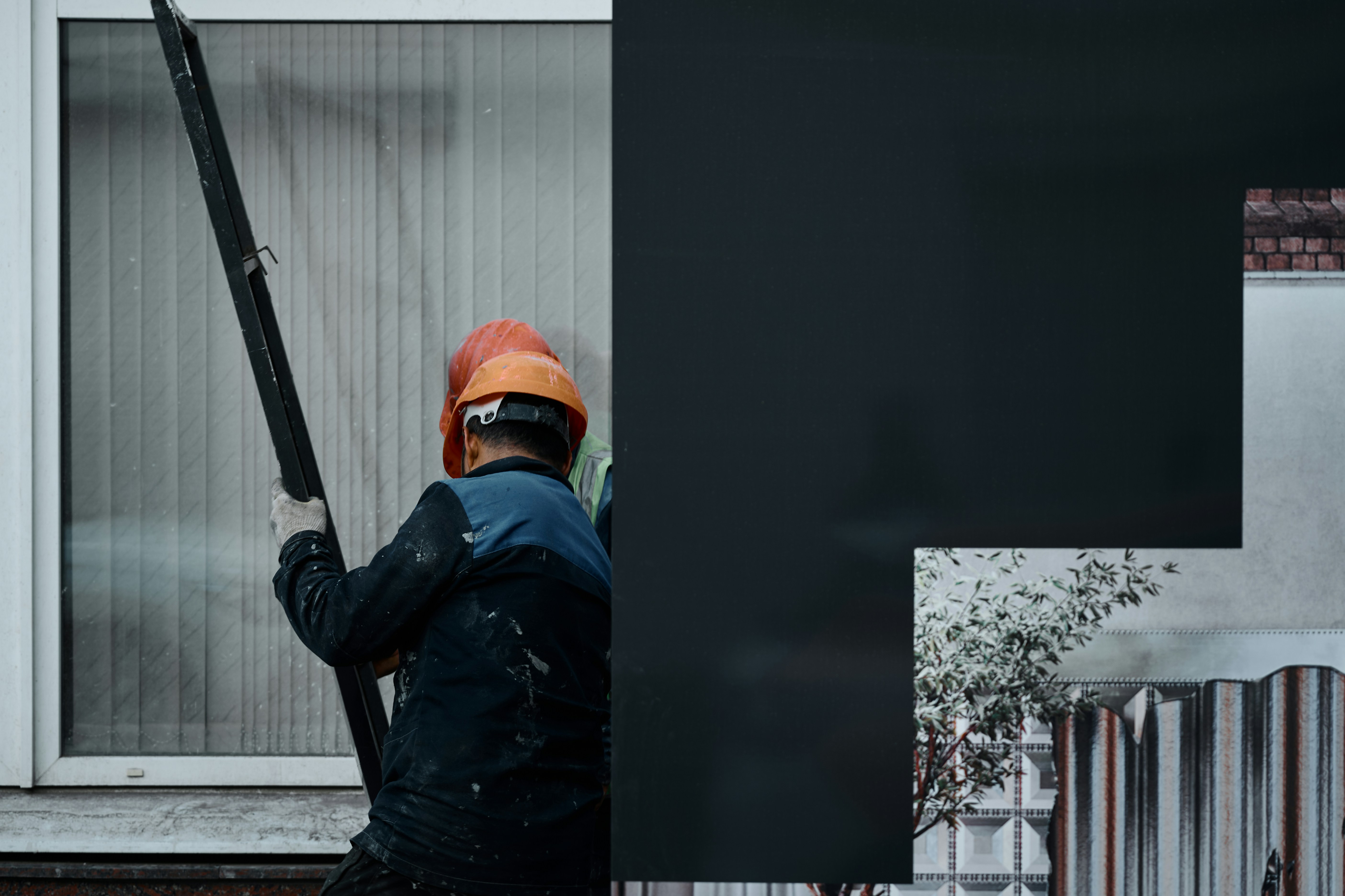 A man holding a baseball bat in front of a building