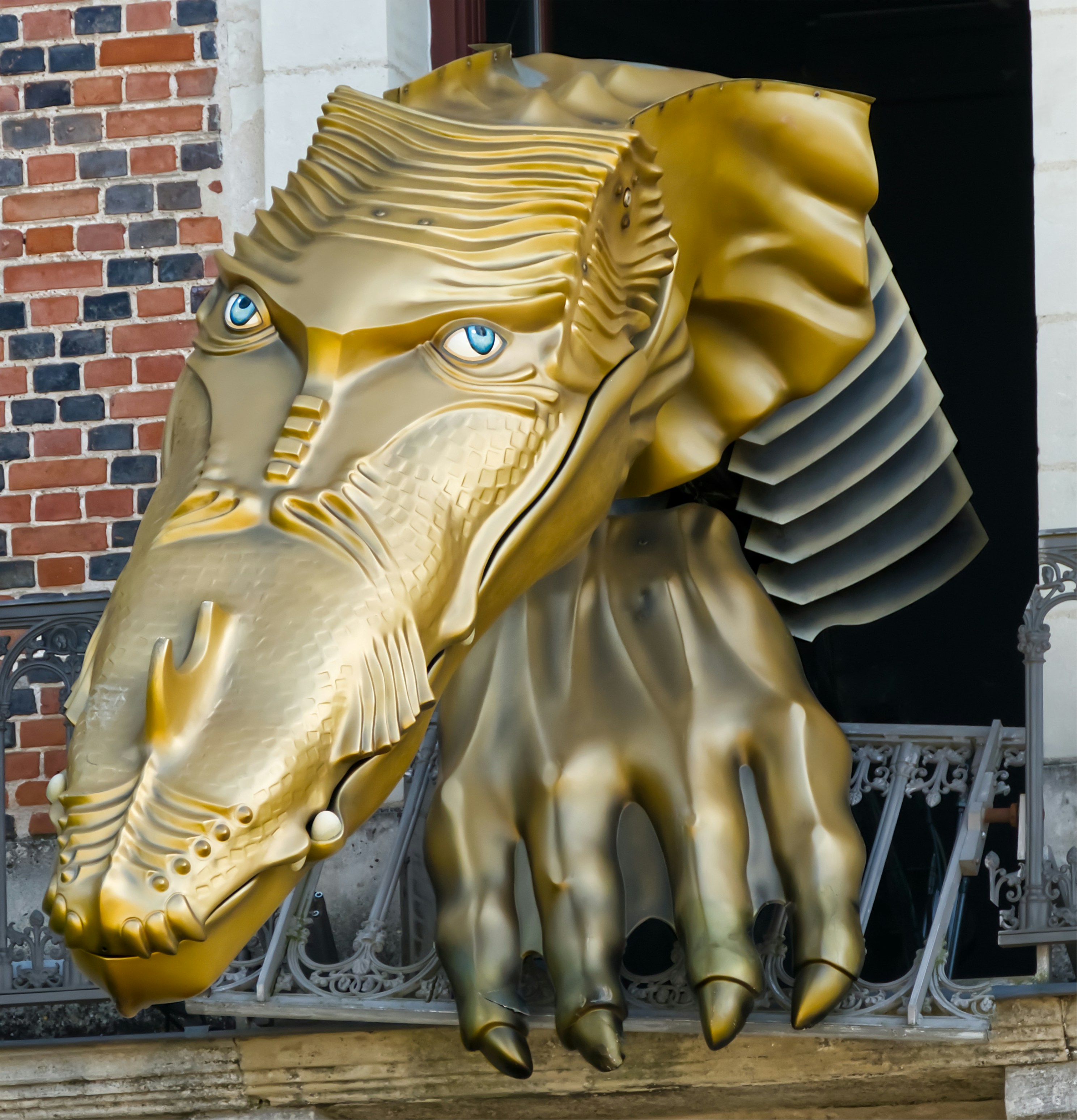 A gold statue of a horse head with blue eyes