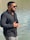 A man in sunglasses standing next to a body of water