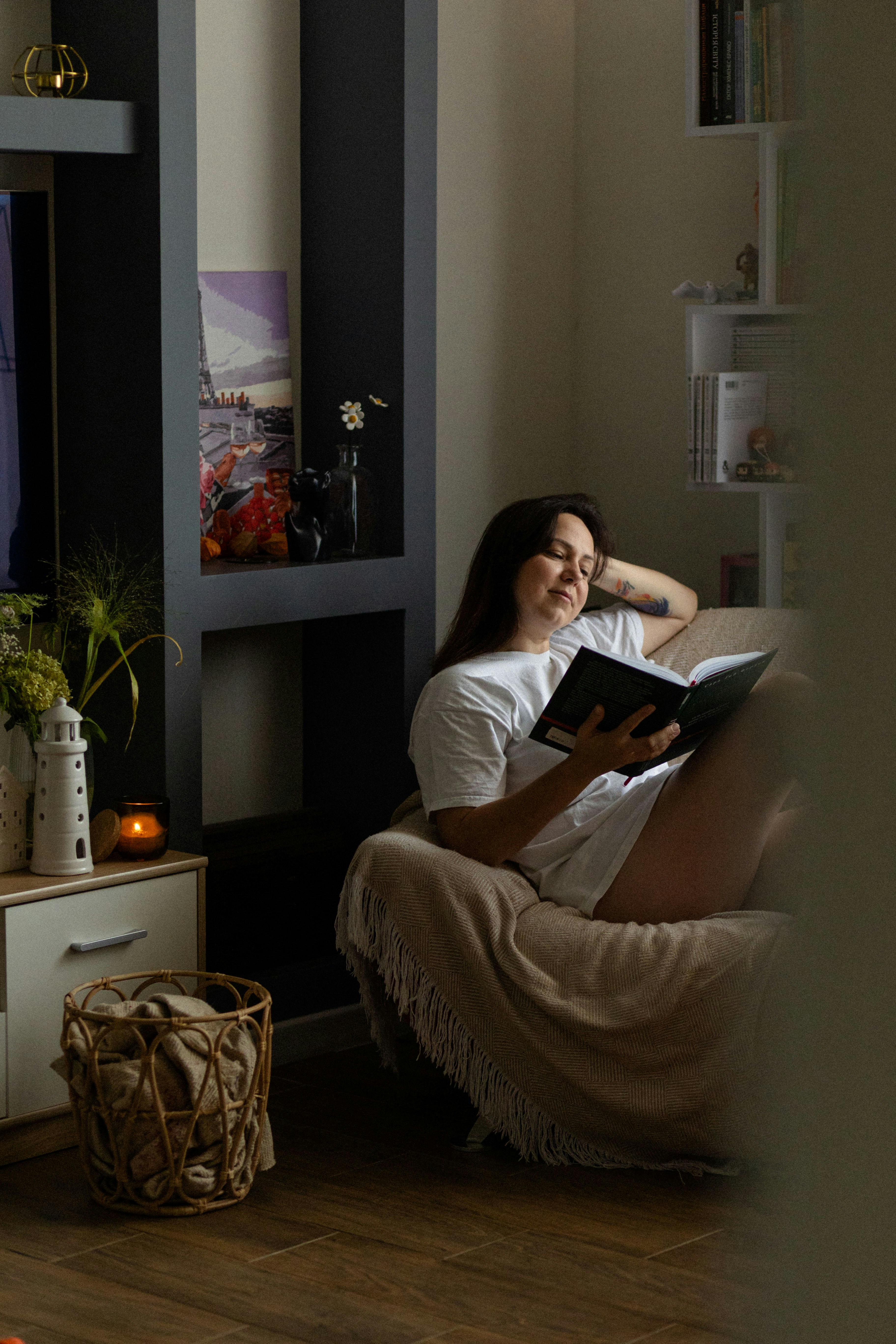 A woman sitting in a chair reading a book