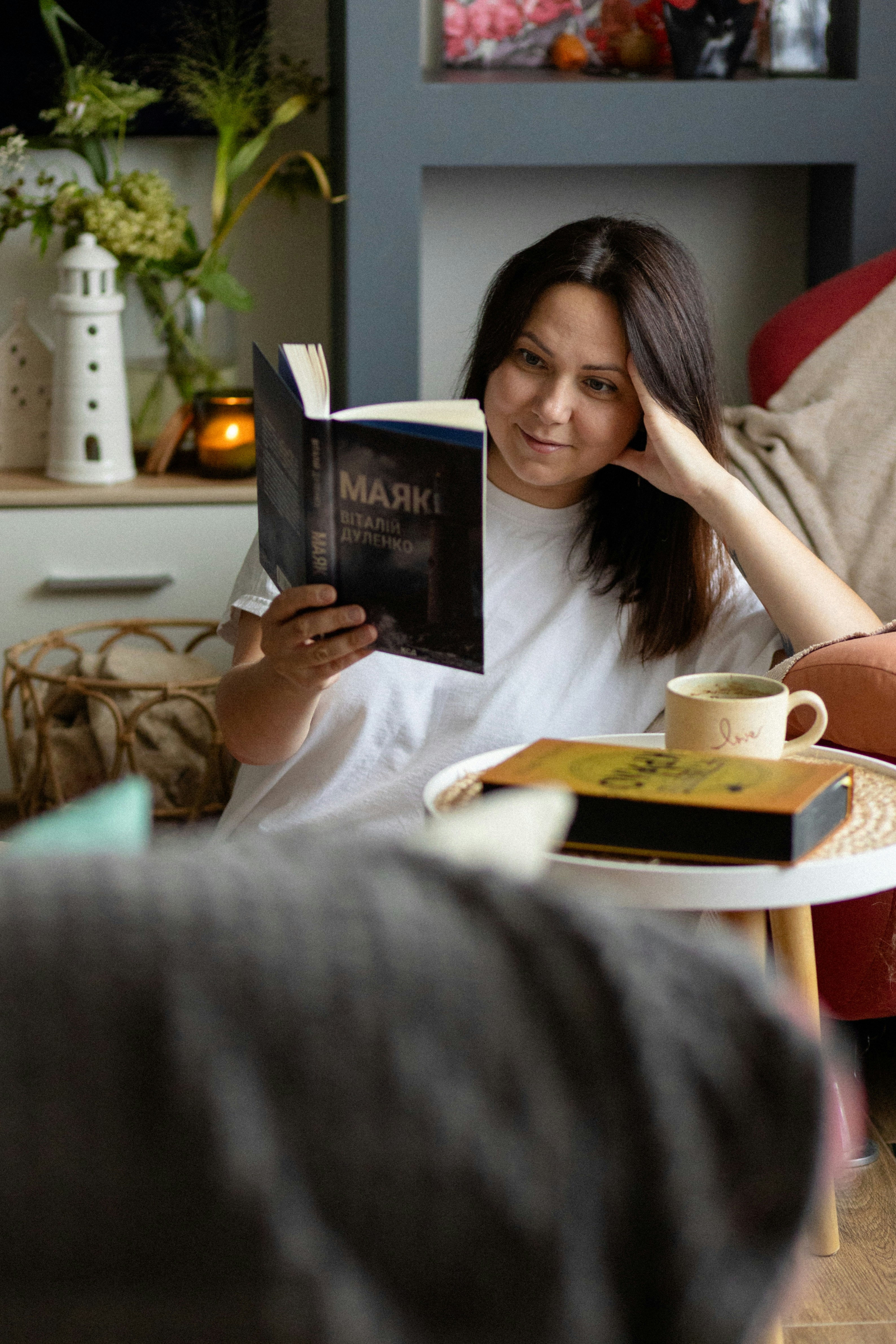 A woman sitting on a couch reading a book