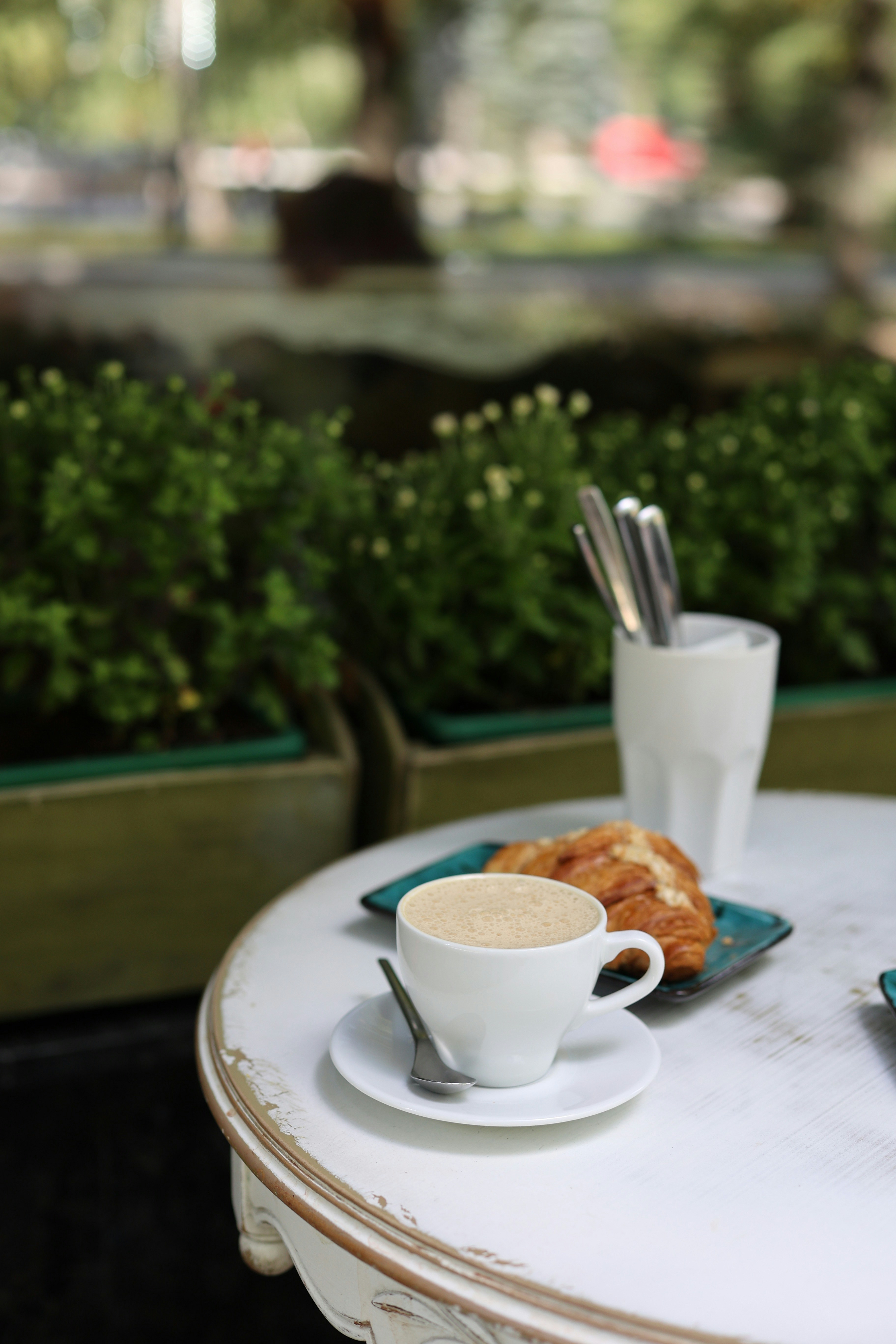 A white table topped with a plate of food and a cup of coffee