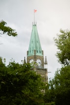 A clock tower with a flag on top of it
