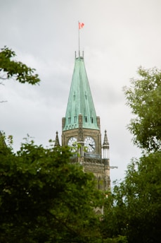 A clock tower with a flag on top of it