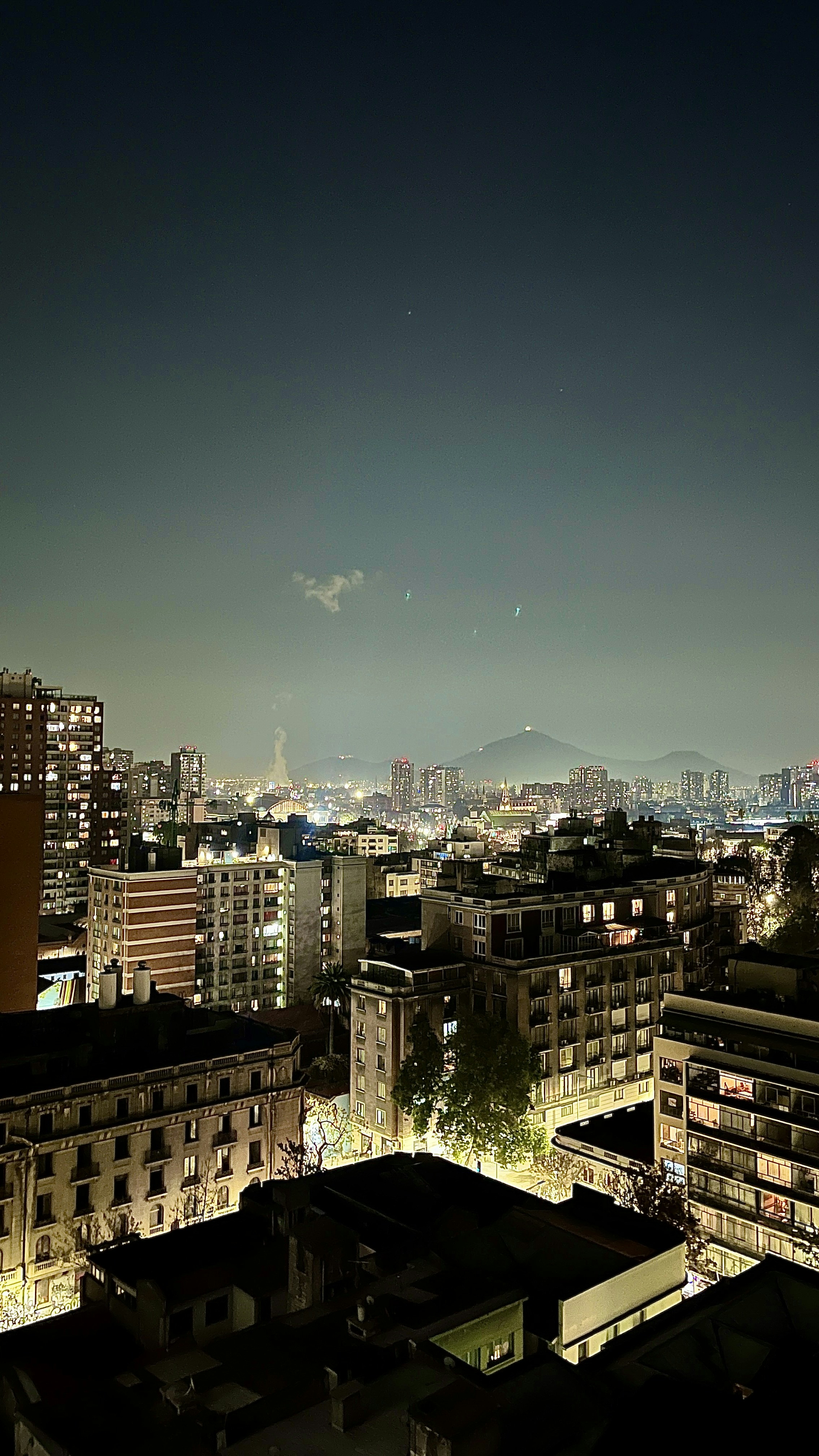 A view of a city at night from the top of a building photo – Free ...