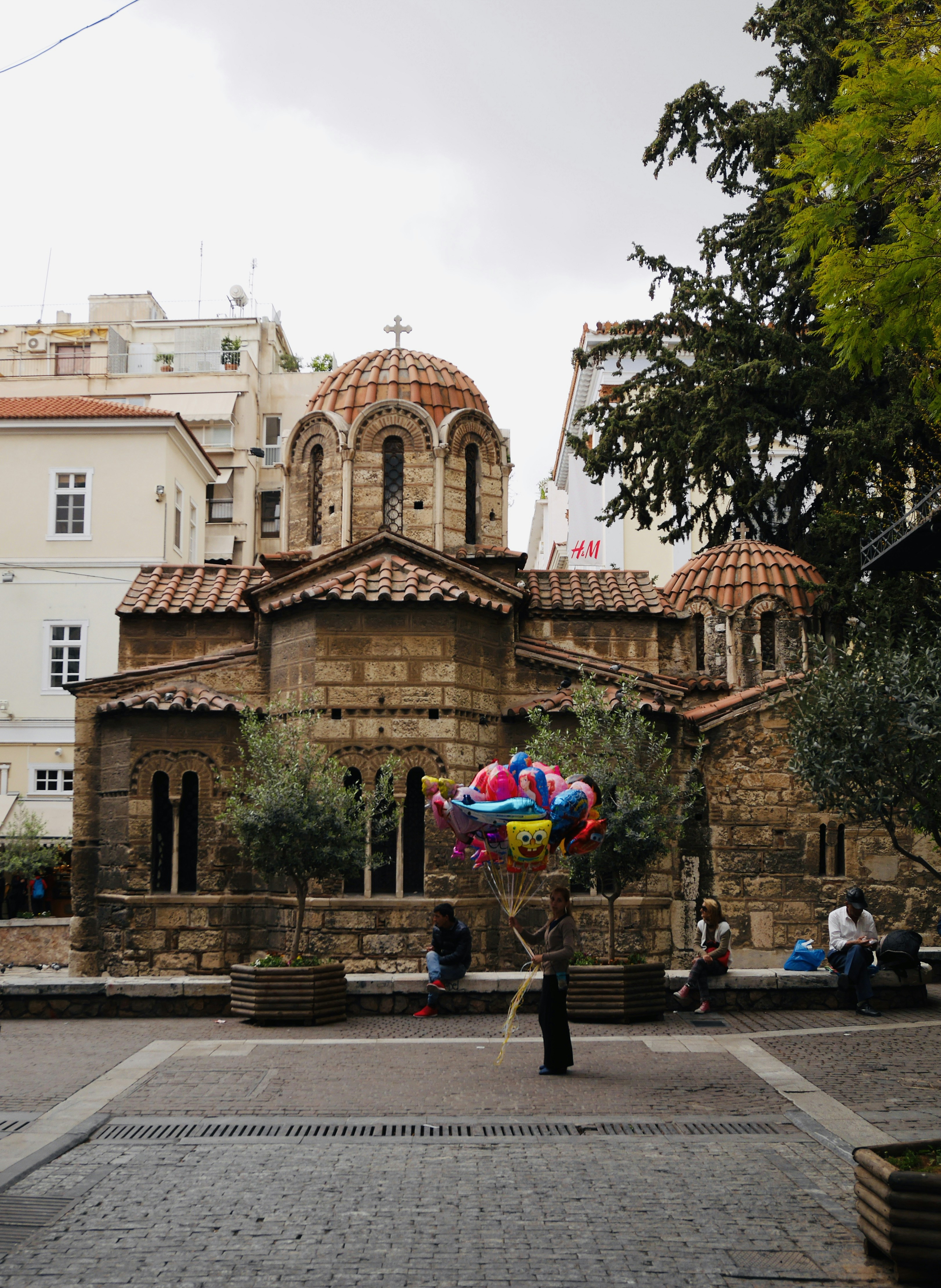 A person holding a colorful balloon in front of a building