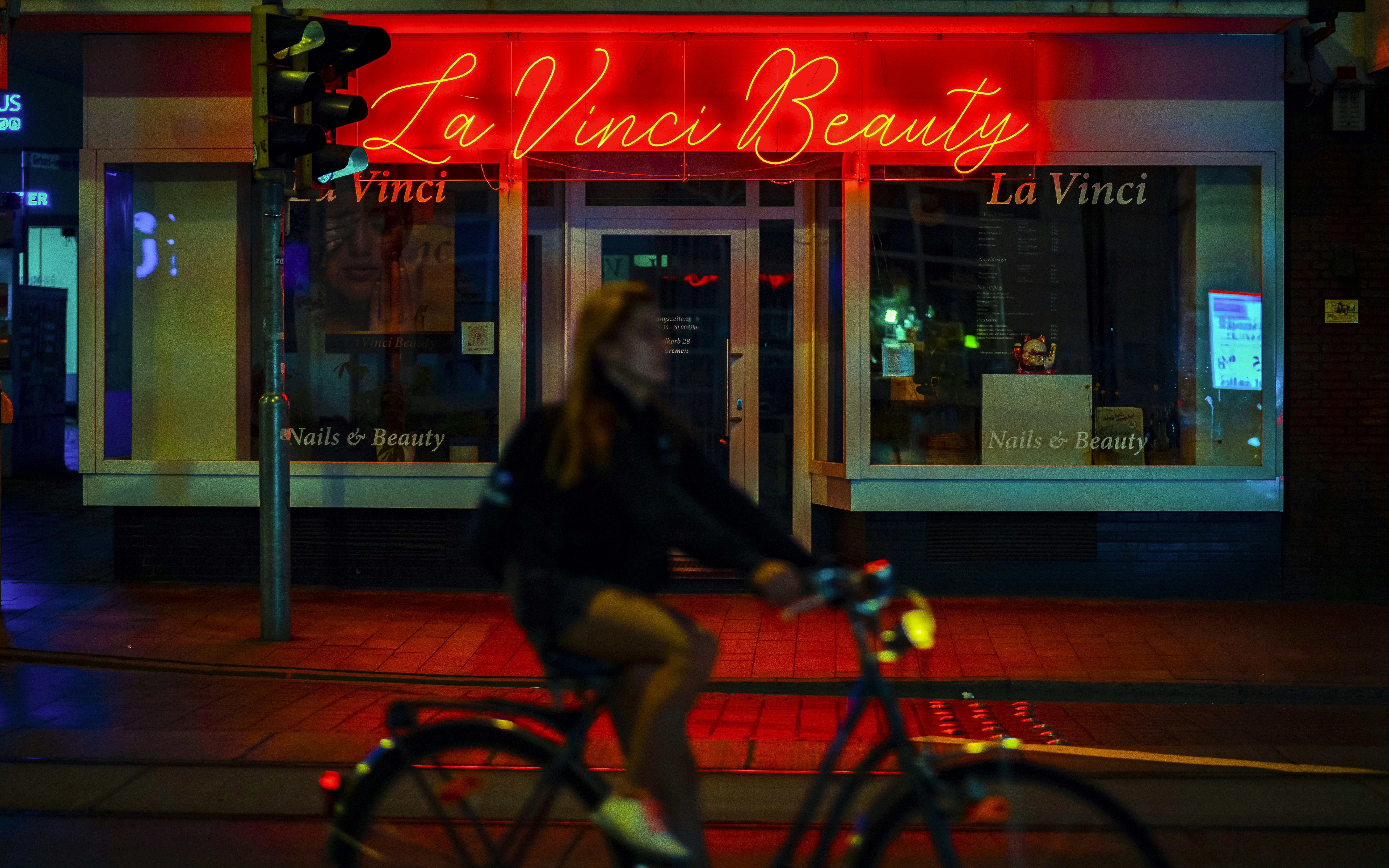 A woman riding a bike down a street at night