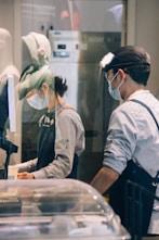 A couple of people in a kitchen preparing food