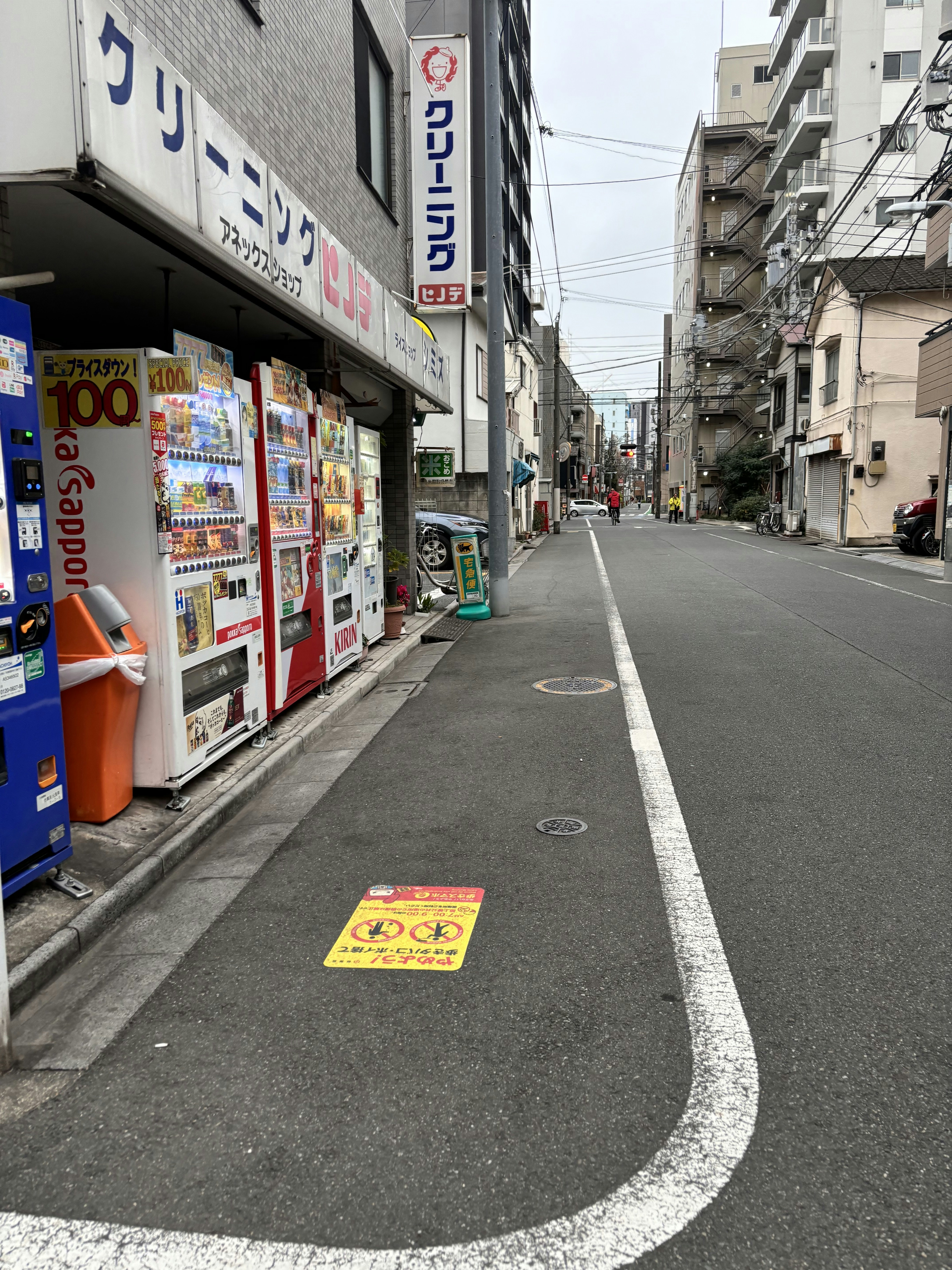A street lined with vending machines next to tall buildings