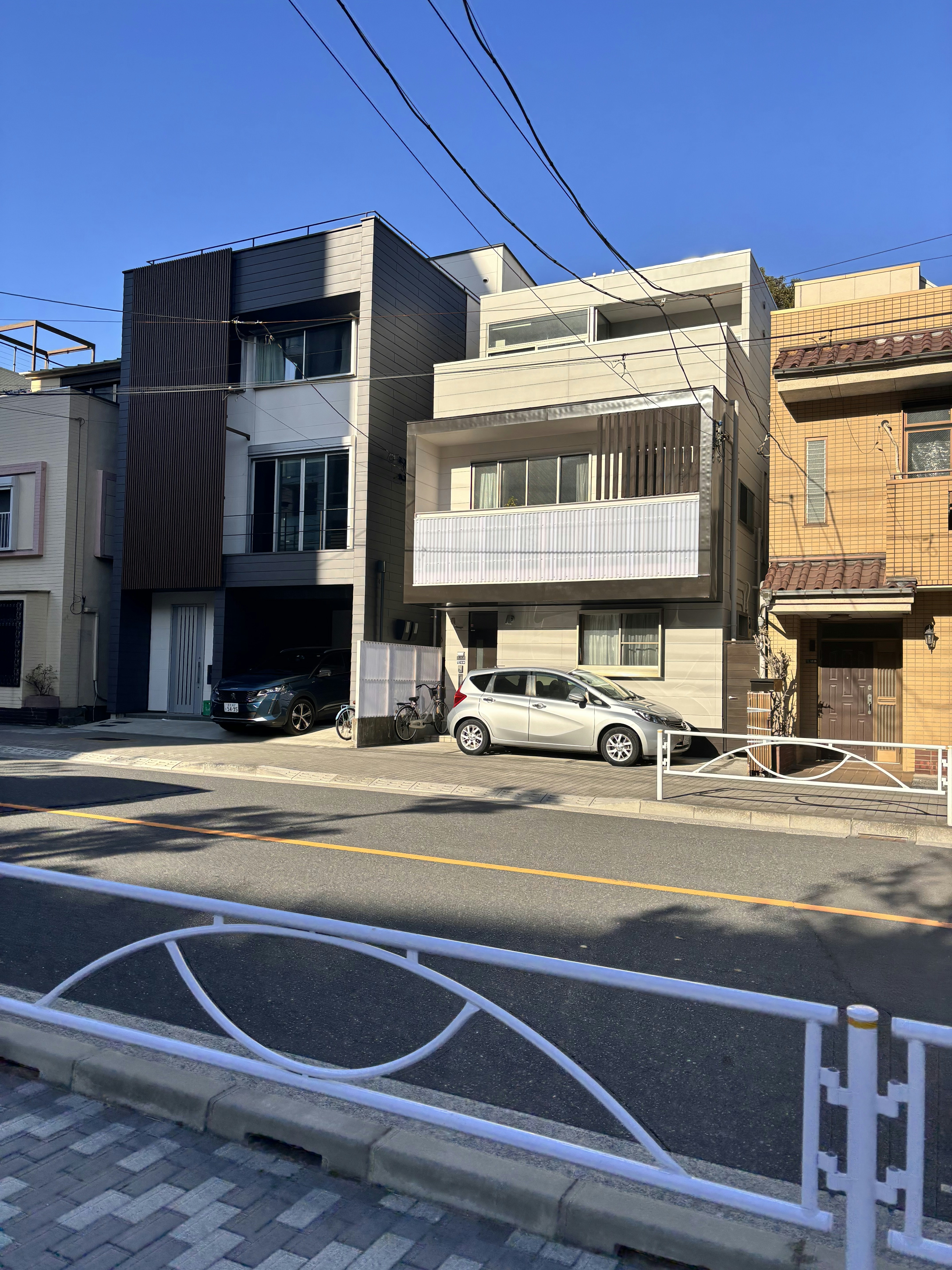 A row of houses on a street with a car parked in front of them