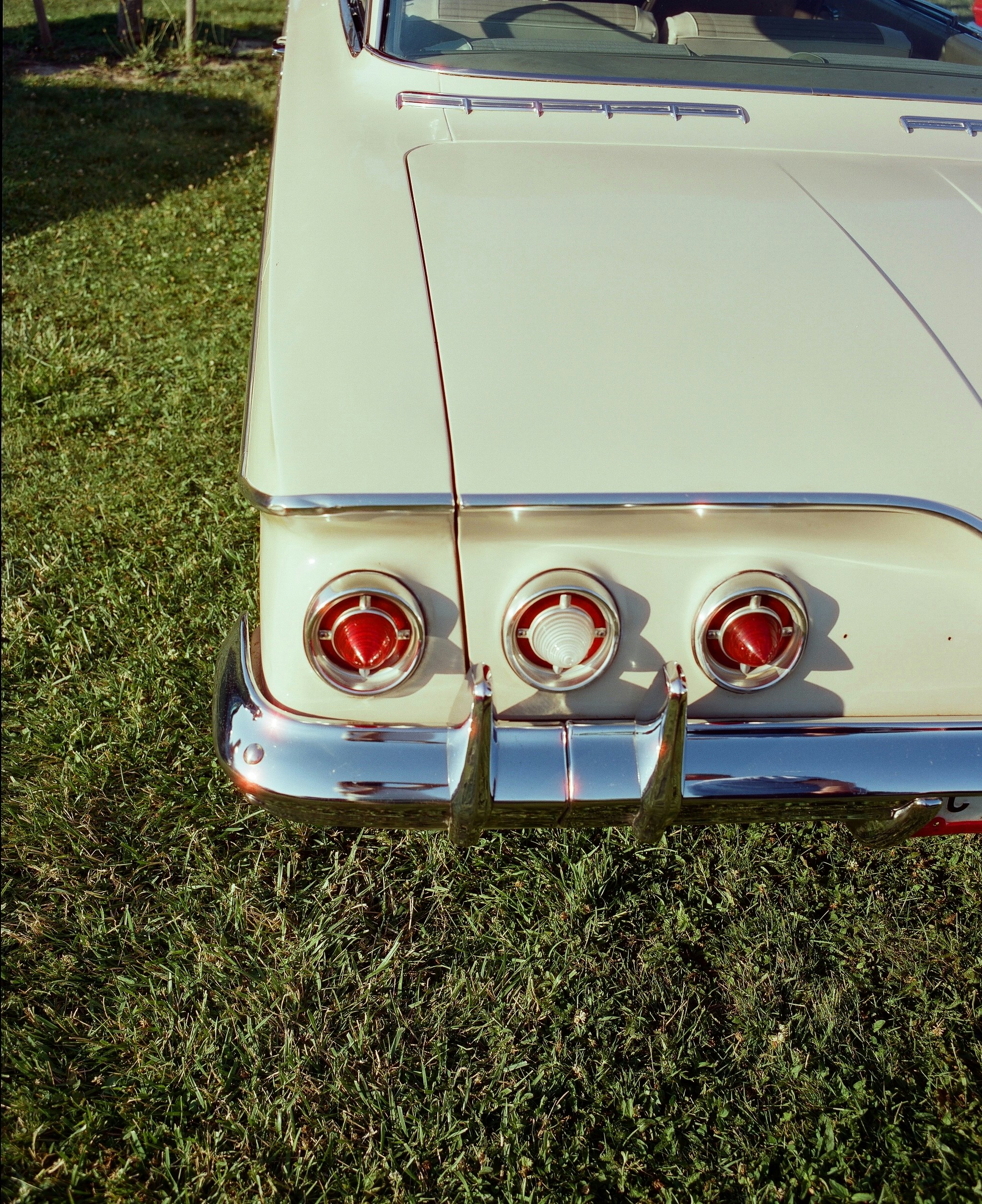 A white car parked on top of a lush green field