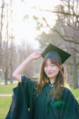 A woman in a graduation gown posing for a picture