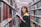 A woman in a library holding a book