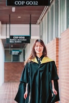 A woman in a graduation gown is walking down a hallway