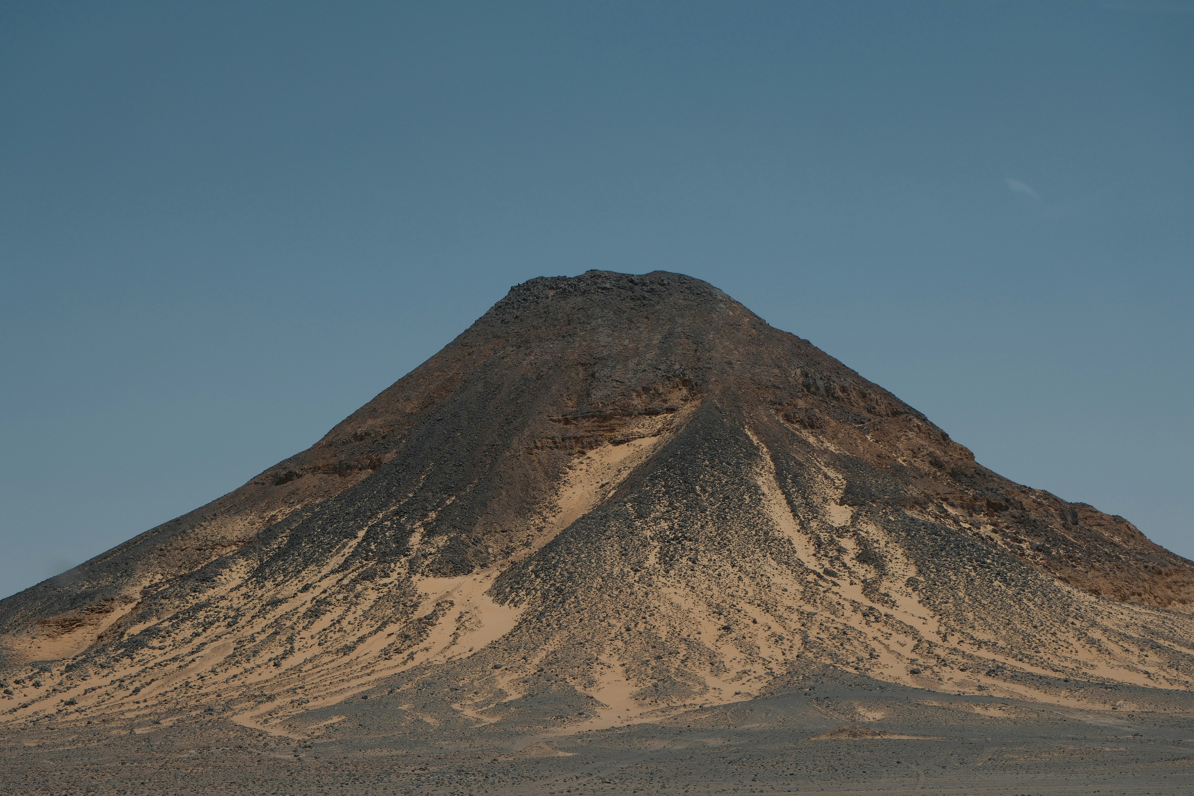 A very tall mountain in the middle of a desert