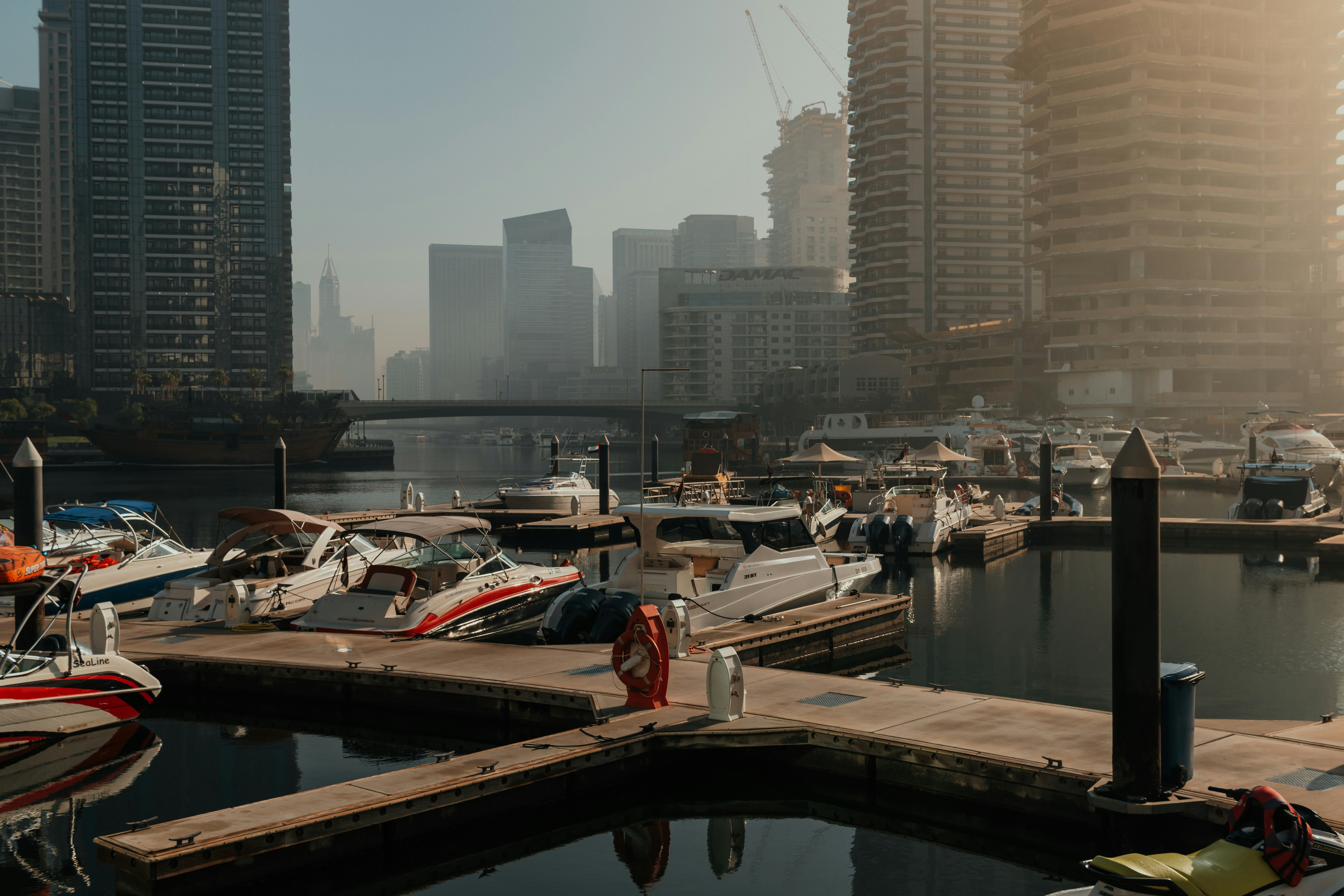 A harbor filled with lots of boats next to tall buildings, Skyline with marina water view, high-rise buildings and boats parked on the water