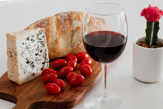 A glass of wine and some bread and tomatoes